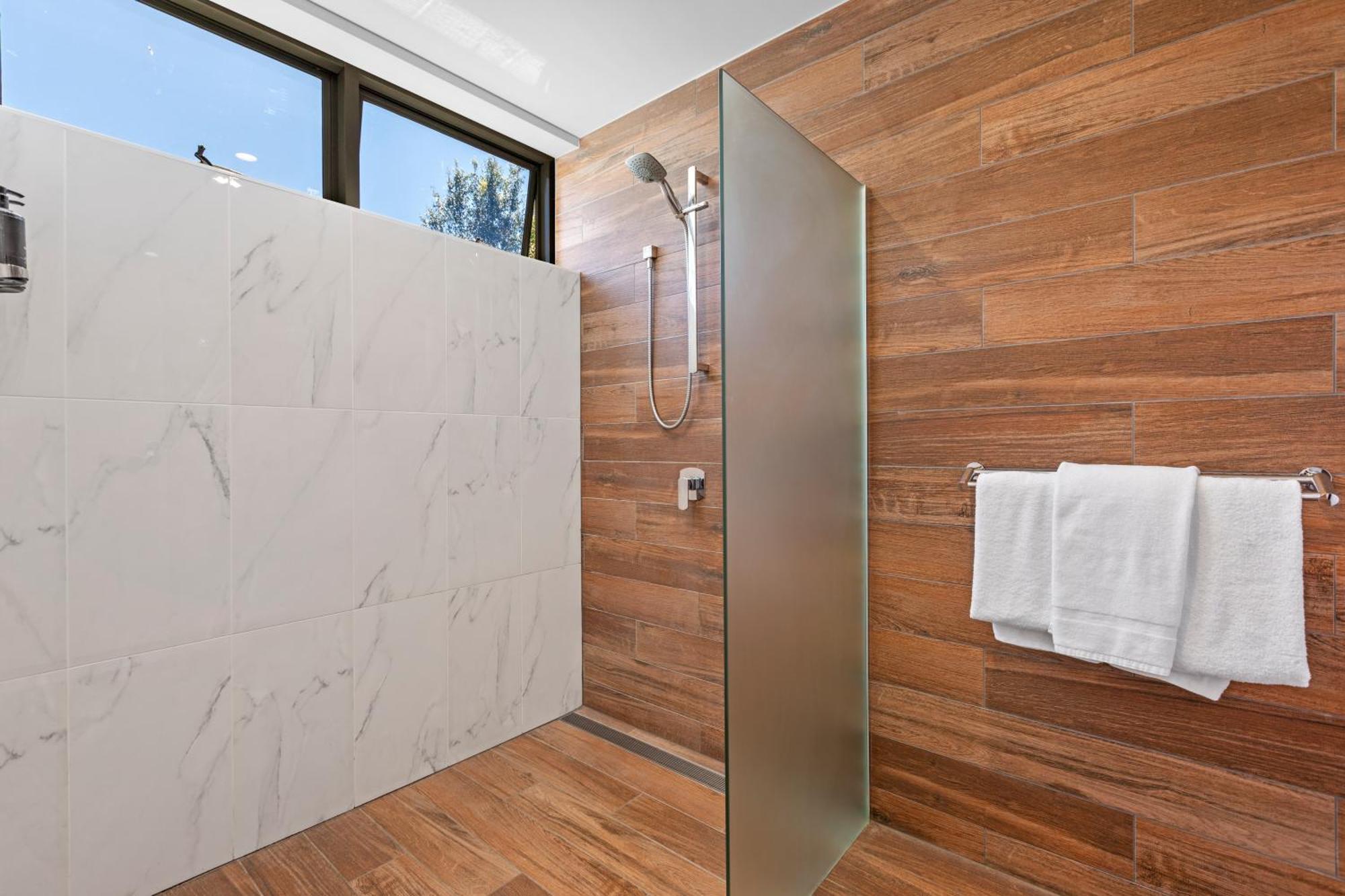 Altitude On מונטוויל חדר תמונה A shower with a fixed shower head and handheld shower head